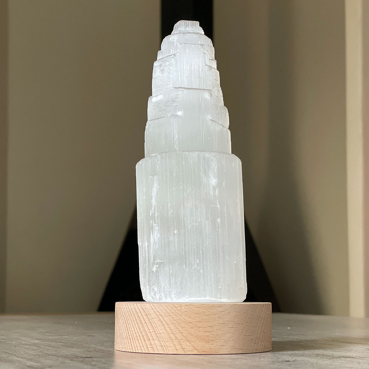 Selenite Lamp - Tower Small - Selenite is a beautiful and versatile crystal that offers numerous benefits, making it a popular choice for both decor and holistic purposes. Its natural beauty and unique translucent appearance make it an eye-catching addition to any home. Selenite emits a soft and warm glow, which makes it an excellent choice for a night light. 