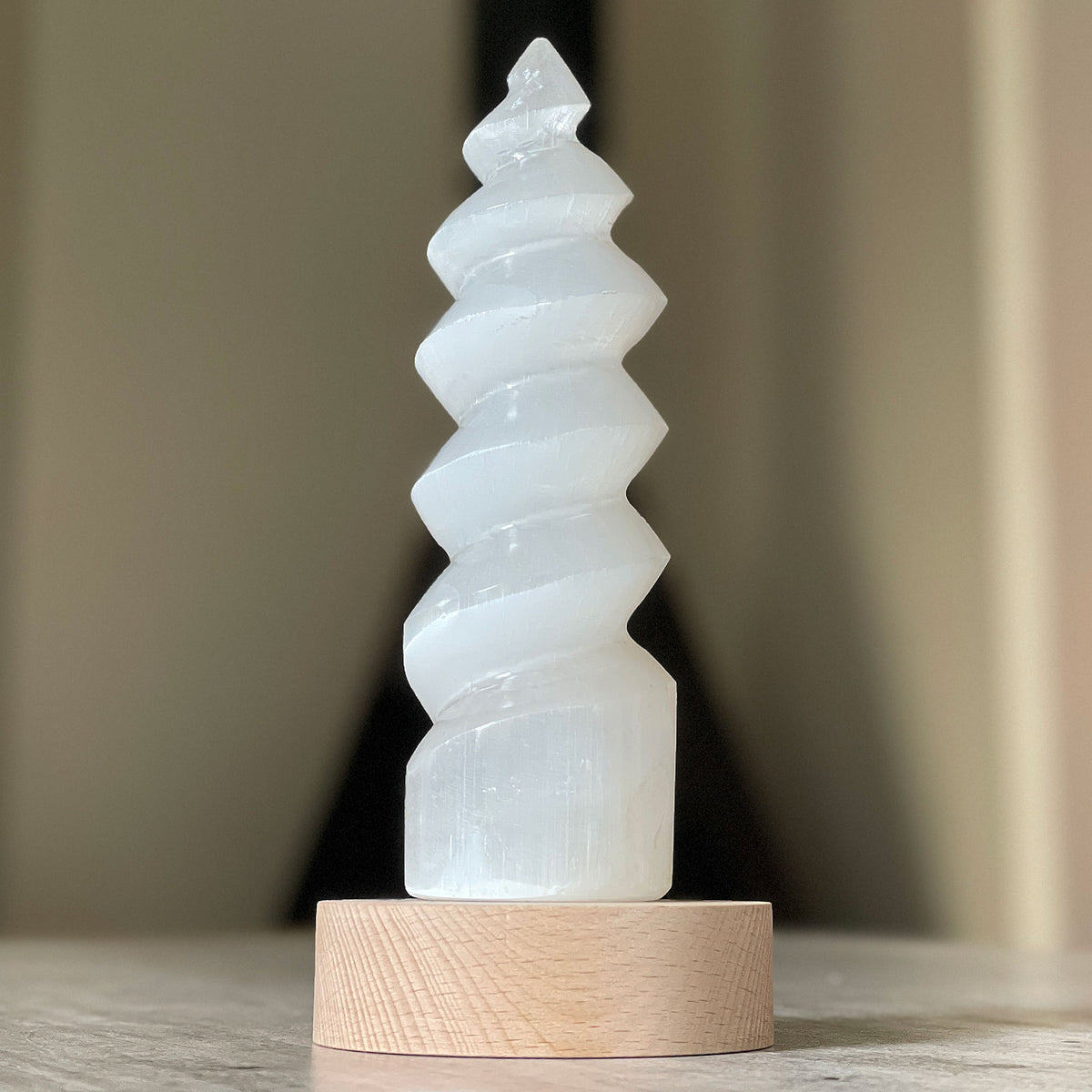 Selenite Lamp - Twister Small - Selenite is a beautiful and versatile crystal that offers numerous benefits, making it a popular choice for both decor and holistic purposes. Its natural beauty and unique translucent appearance make it an eye-catching addition to any home. Selenite emits a soft and warm glow, which makes it an excellent choice for a night light.