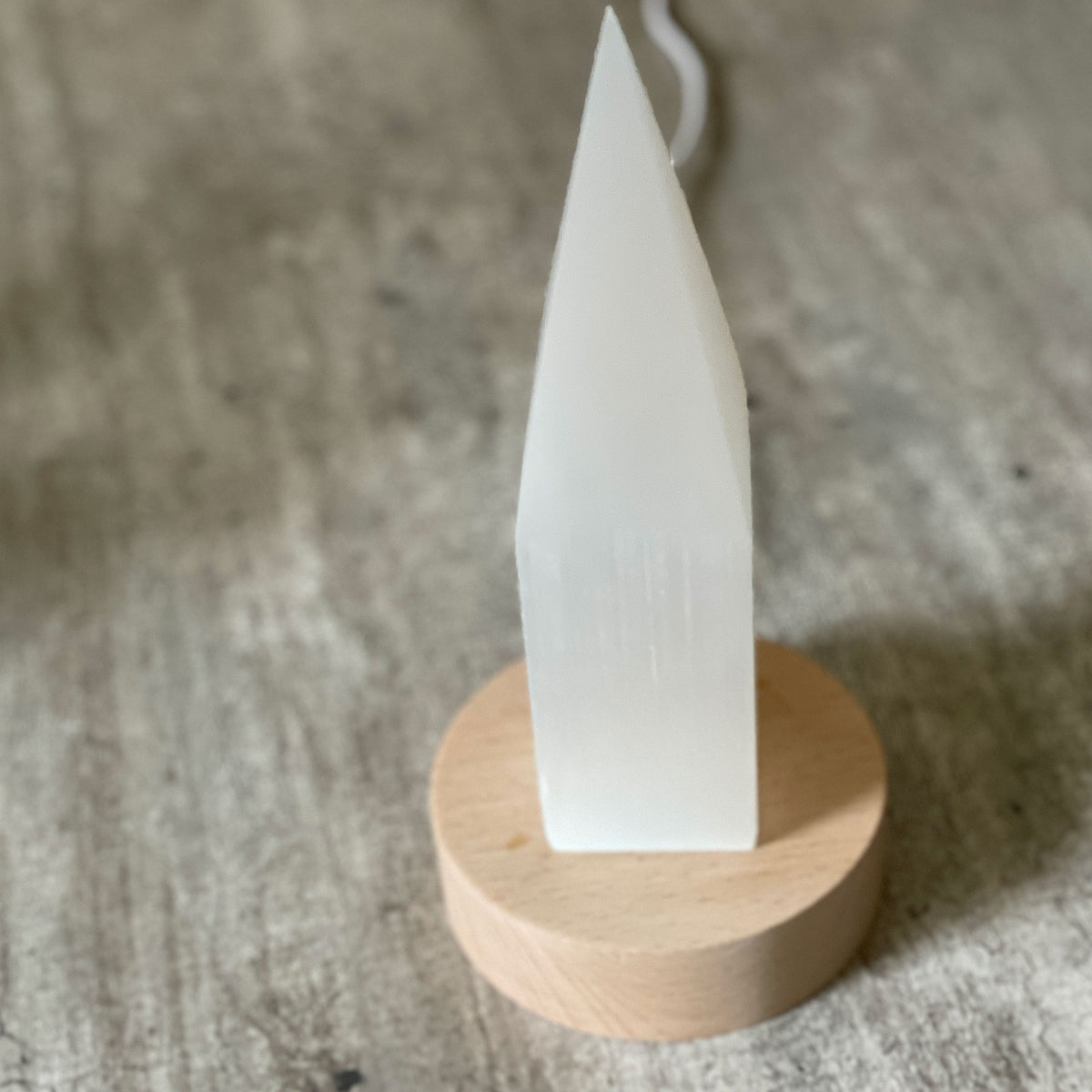 Selenite Lamp - Pencil Point Small - Selenite is a beautiful and versatile crystal that offers numerous benefits, making it a popular choice for both decor and holistic purposes. Its natural beauty and unique translucent appearance make it an eye-catching addition to any home. Selenite emits a soft and warm glow, which makes it an excellent choice for a night light.
